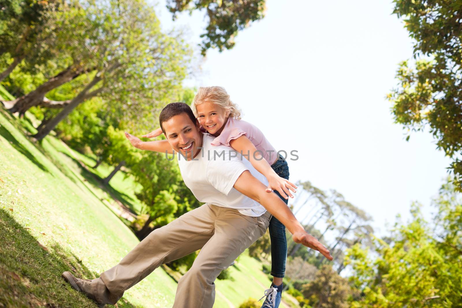 Little girl playing with her father in the park by Wavebreakmedia