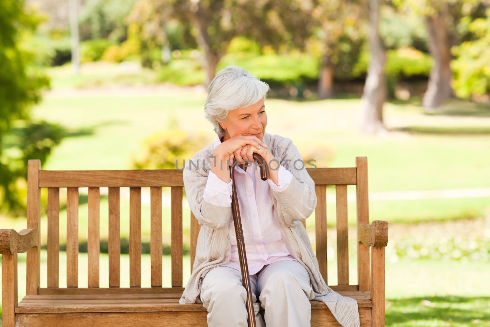 Woman with her walking stick during the summer in the park