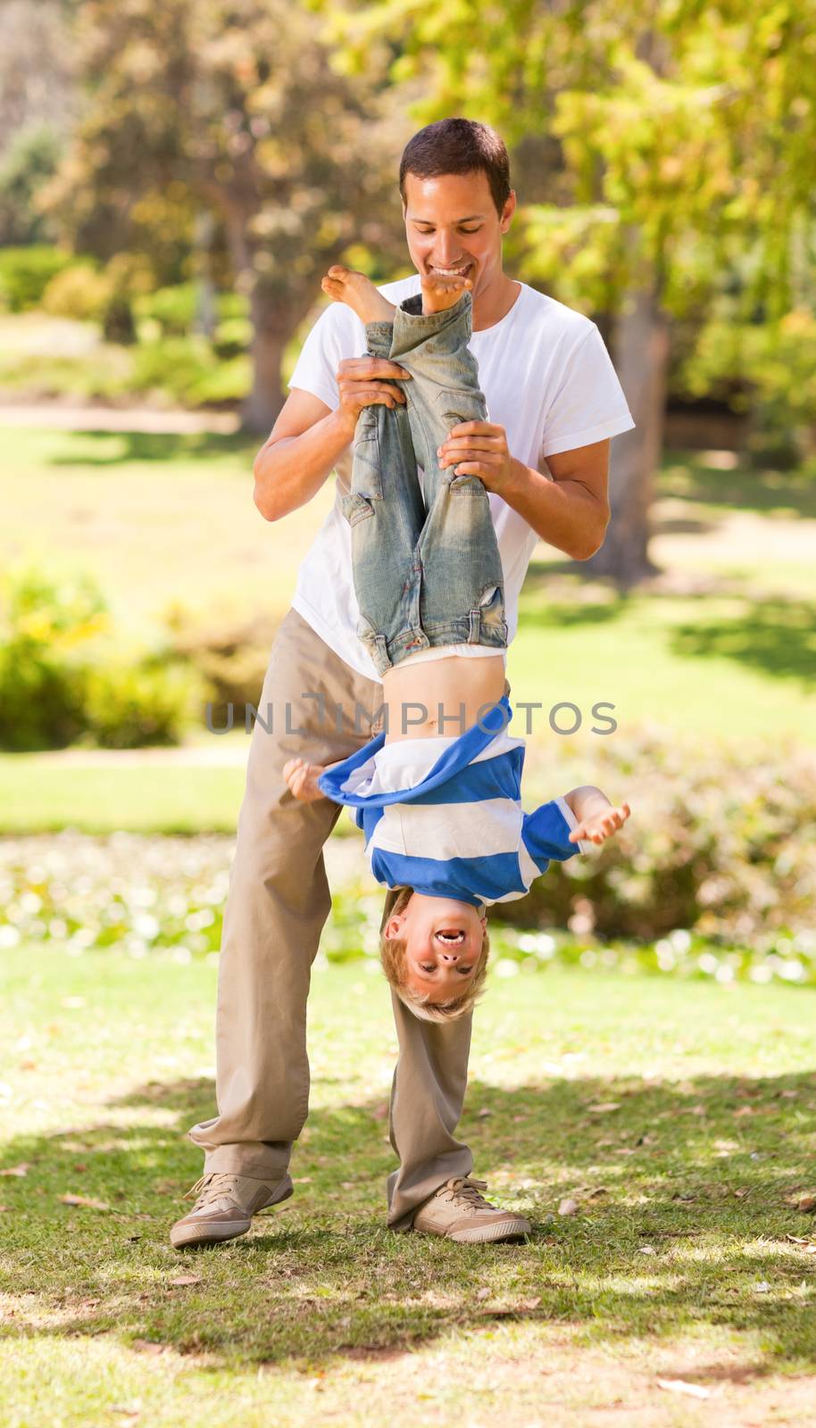 Father playing with his son in the park during the summer 