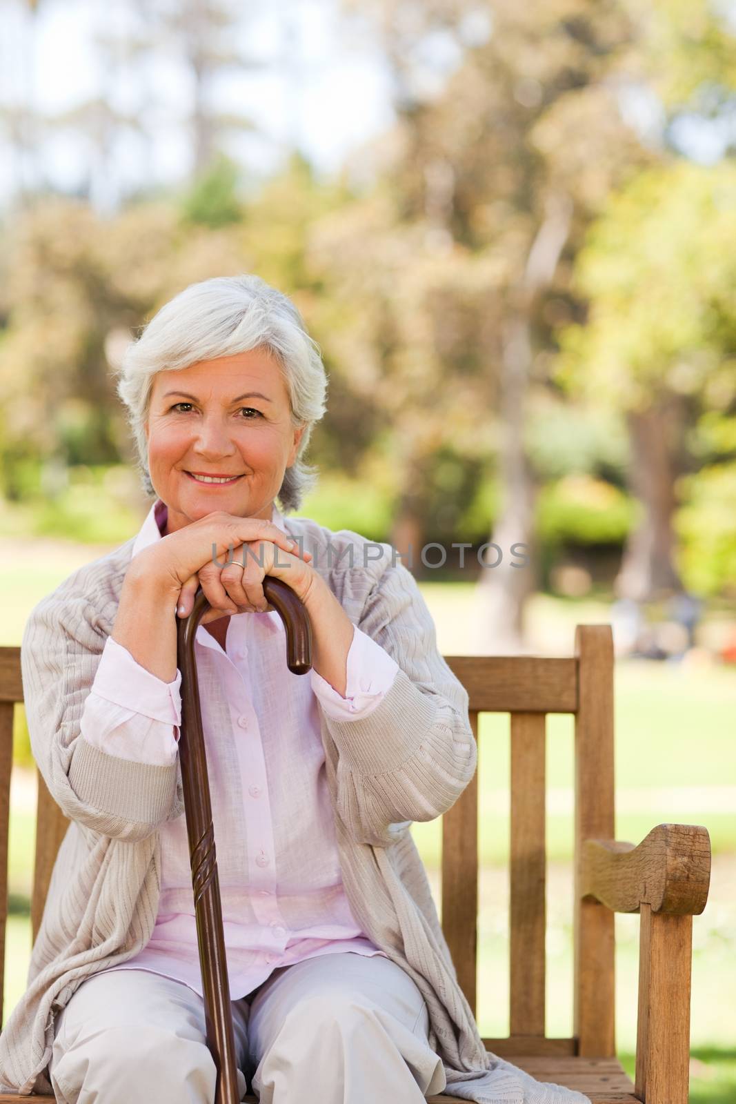 Woman with her walking stick in the park during the summer 