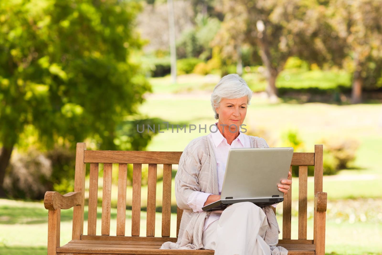 Retired woman working on her laptop during the summer 