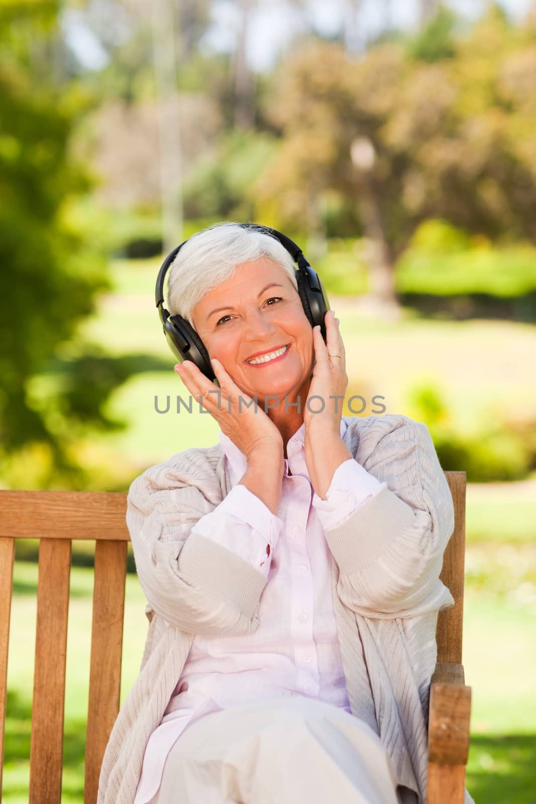 Senior woman listening to some music during the summer 