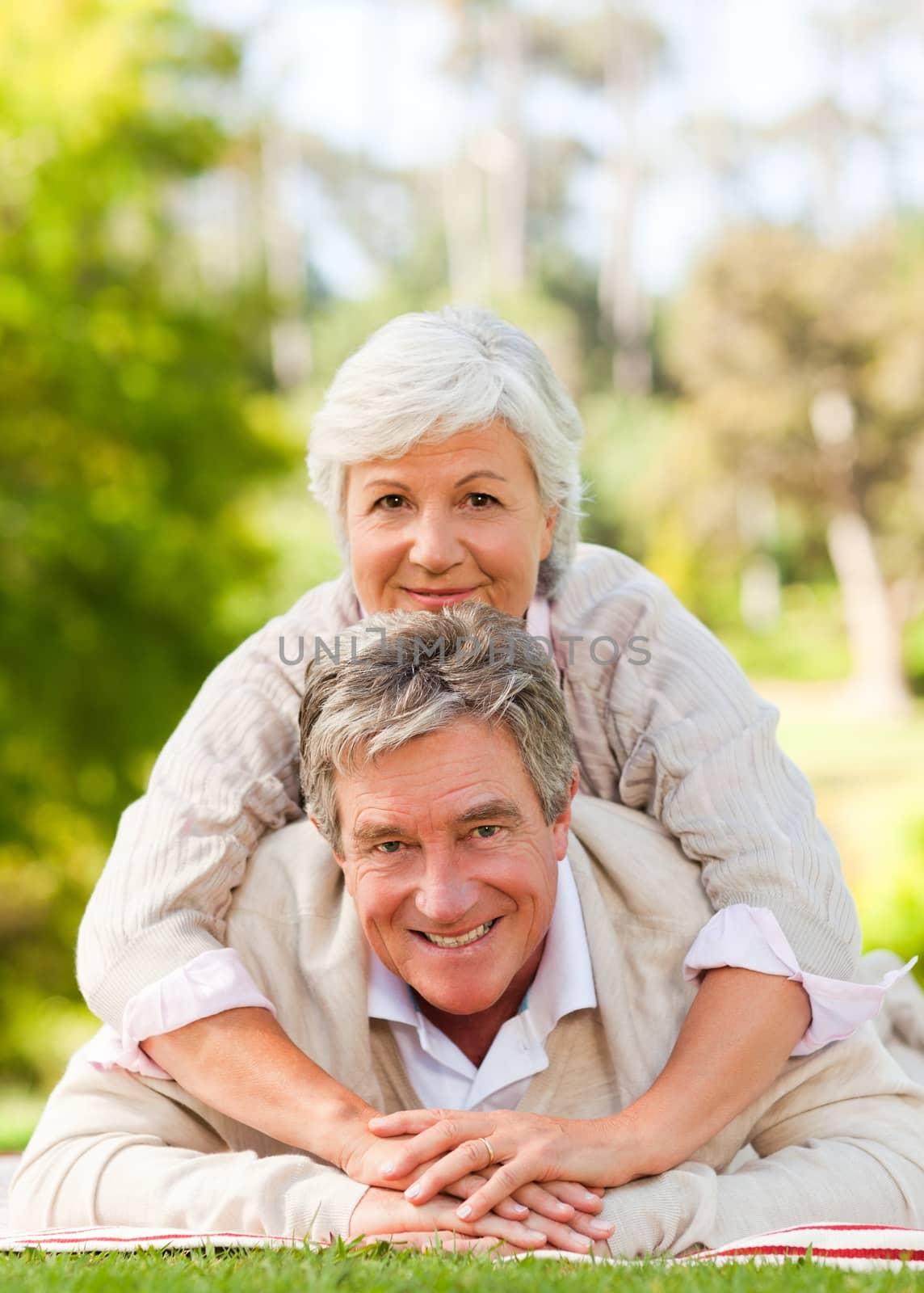 Mature couple lying down in the park during the summer