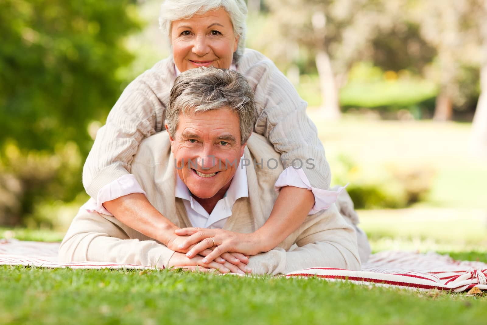 Mature couple lying down in the park during the summer