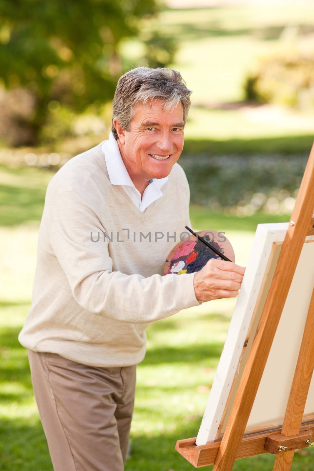 Elderly man painting in the park by Wavebreakmedia