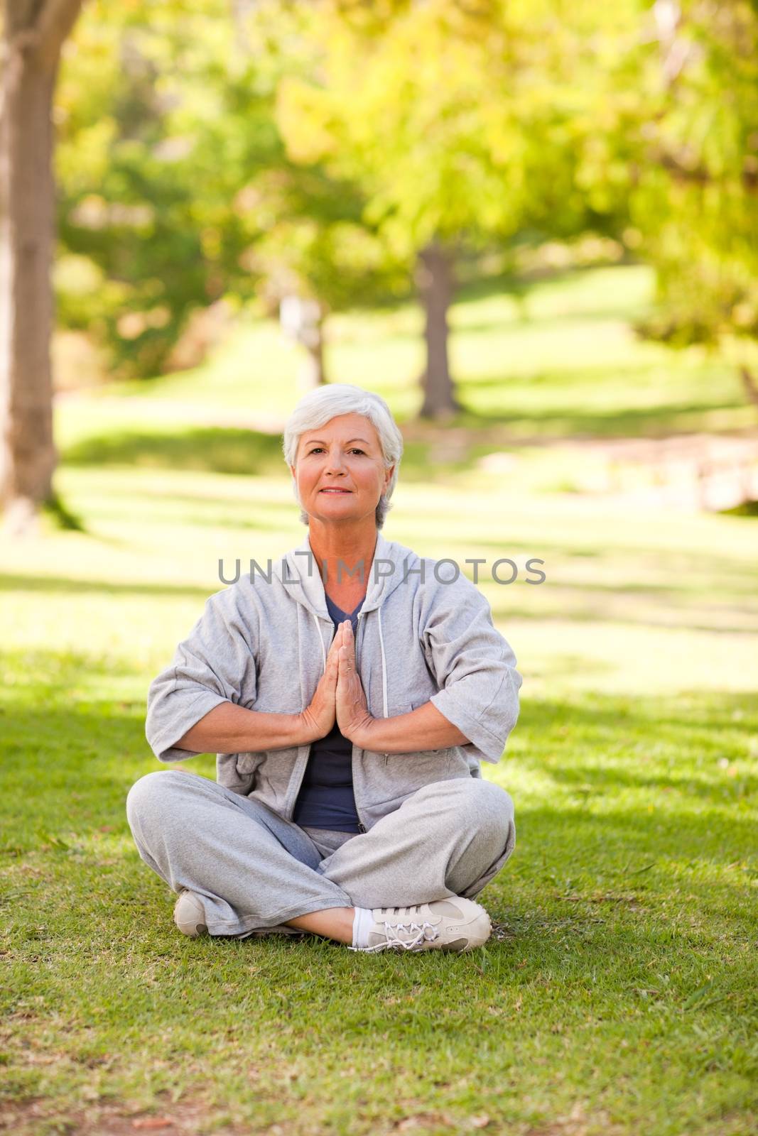Mature woman practicing yoga in the park by Wavebreakmedia