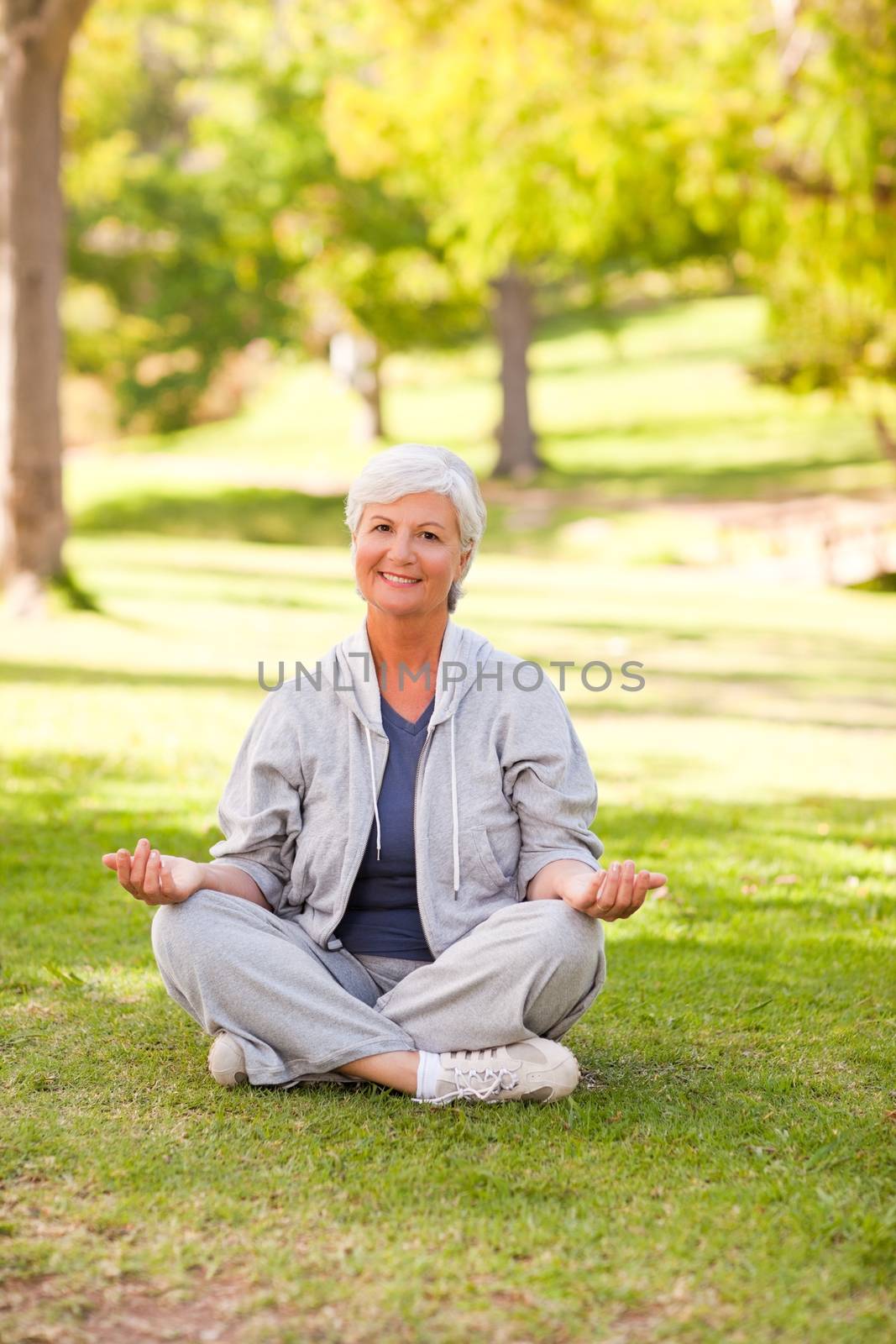 Mature woman practicing yoga in the park by Wavebreakmedia