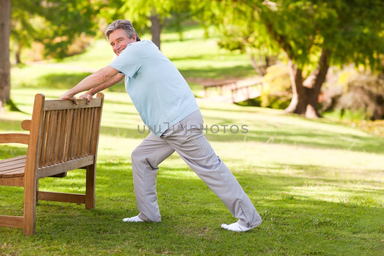 Retired man doing his stretches in the park by Wavebreakmedia