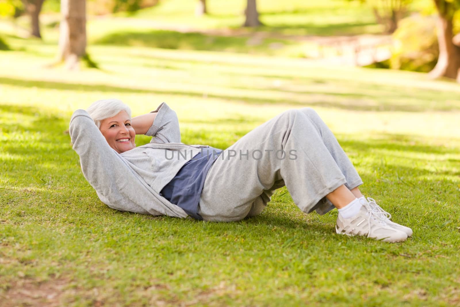 Retired woman doing her stretches in the park during the summer