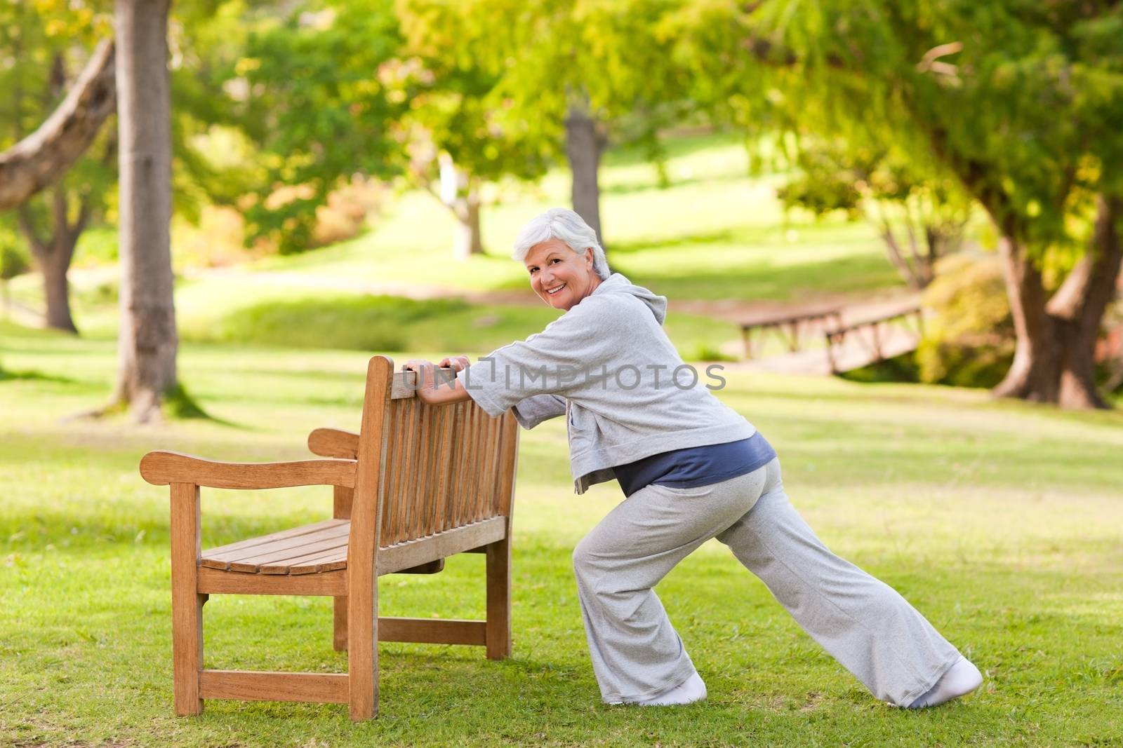 Senior woman doing her stretches in the park during the summer