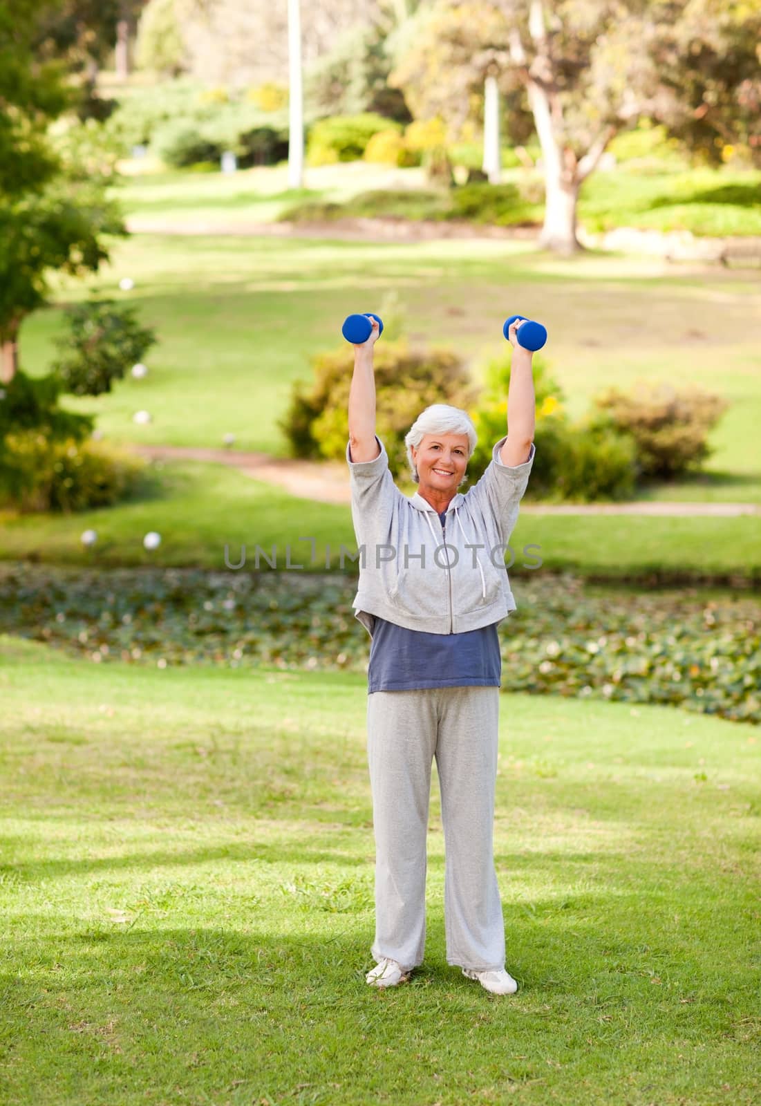 Mature woman doing her exercises in the park during the summer