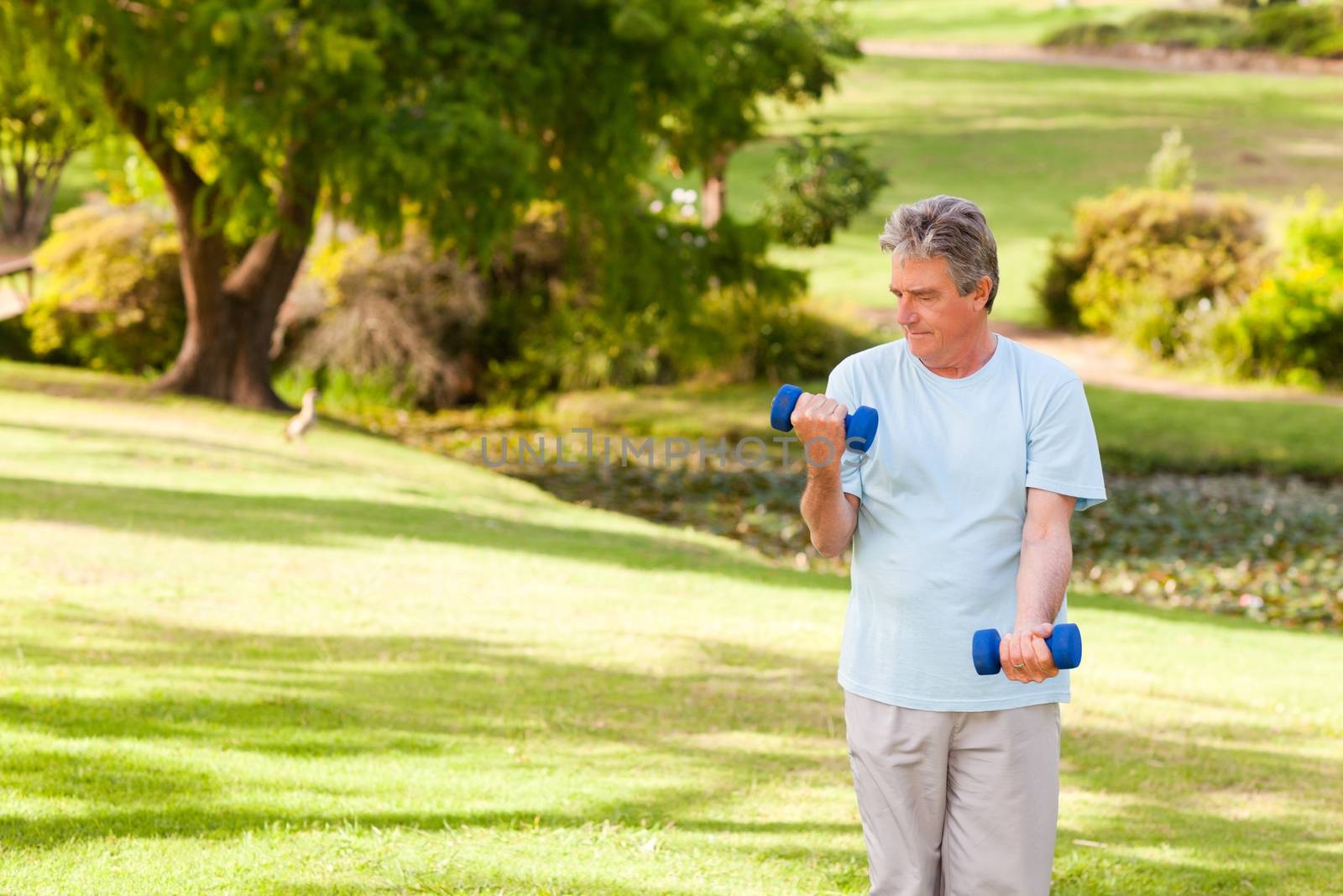 Elderly man doing his exercises in the park by Wavebreakmedia