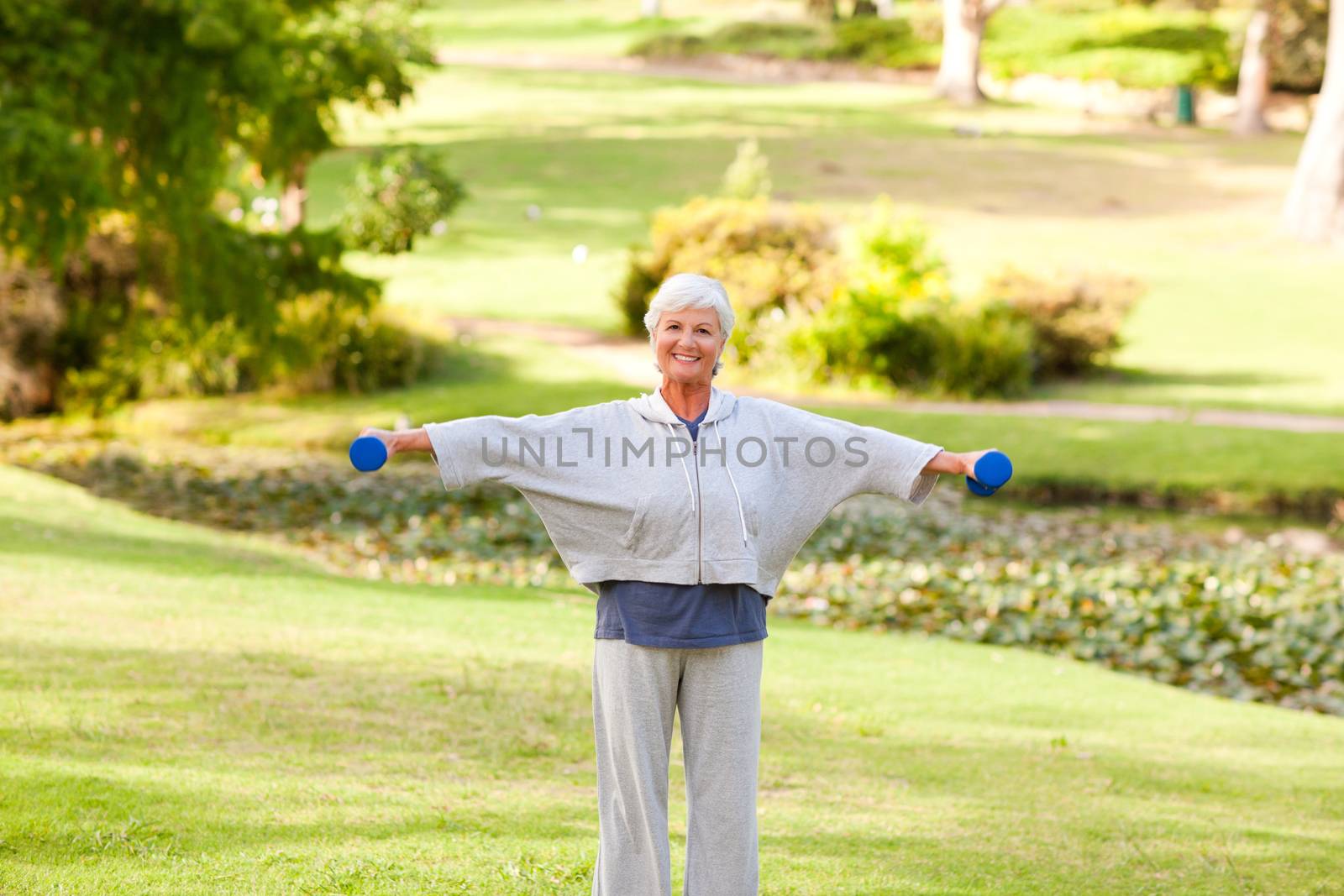 Mature woman doing her exercises in the park by Wavebreakmedia