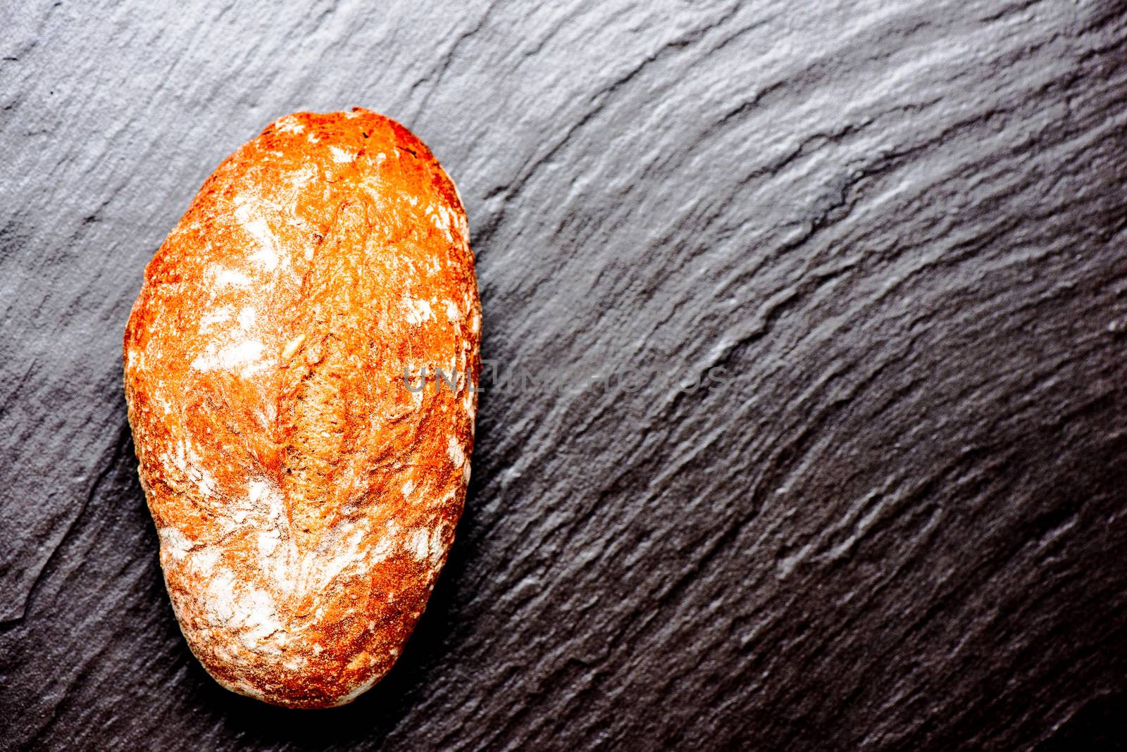 Bread loaf on stone surface with copy space