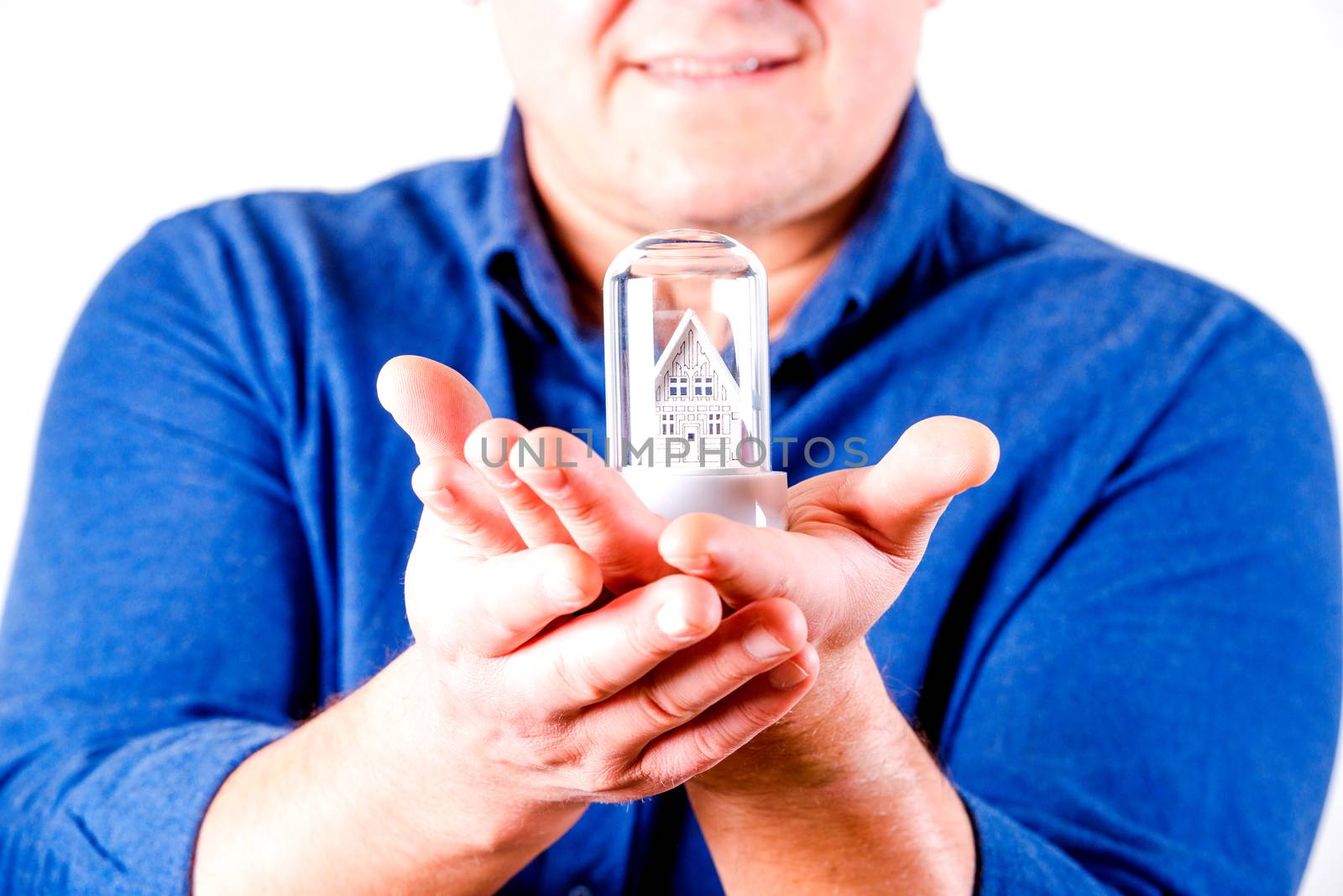 middle aged men in glasses with toy house and  blue shirt