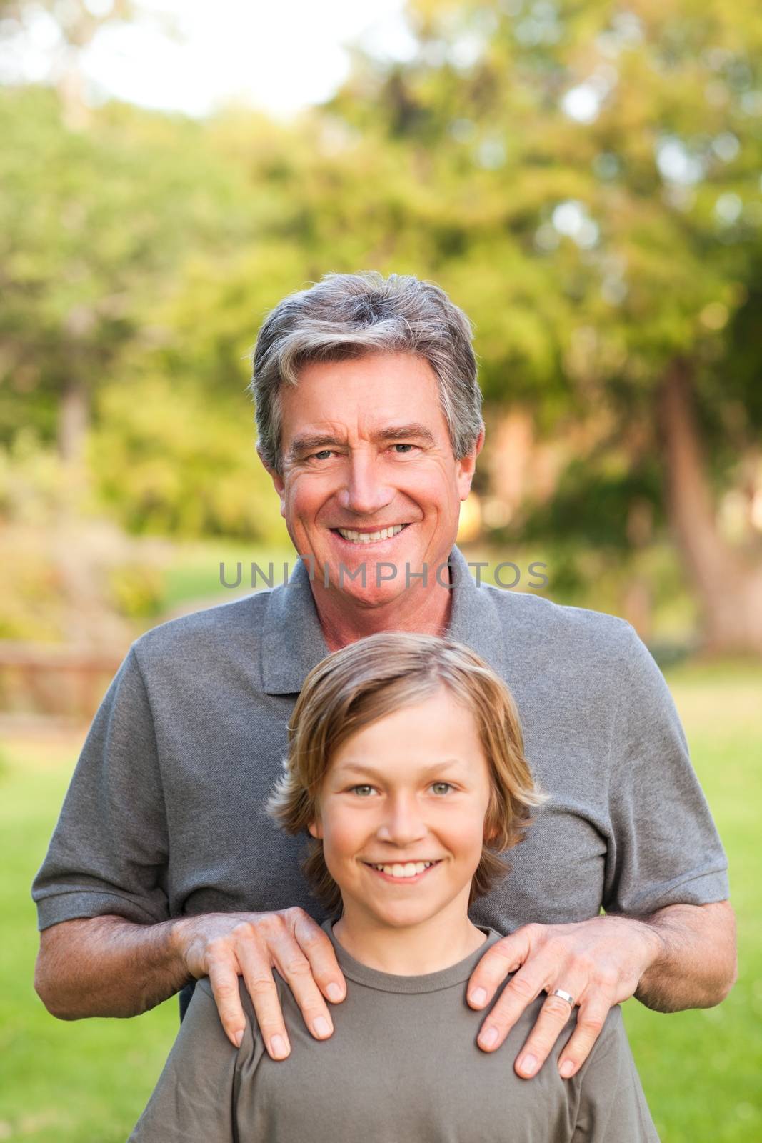Grandfather with his grandson in the park during the summer