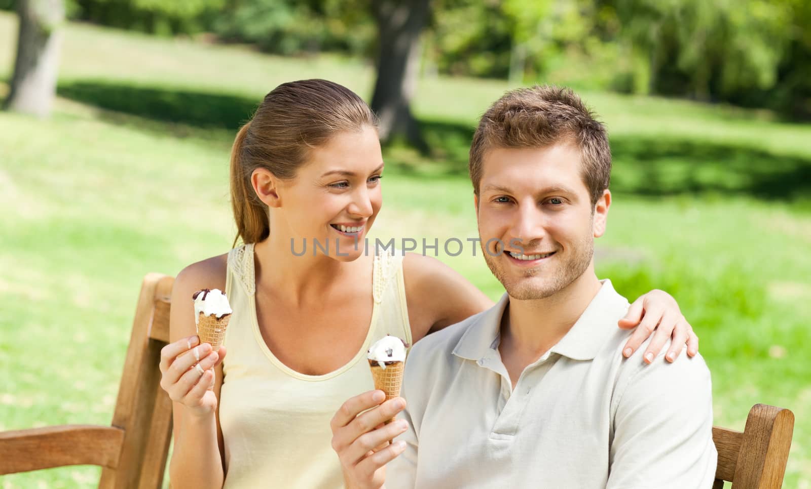 Couple eating an ice cream in the park during the summer