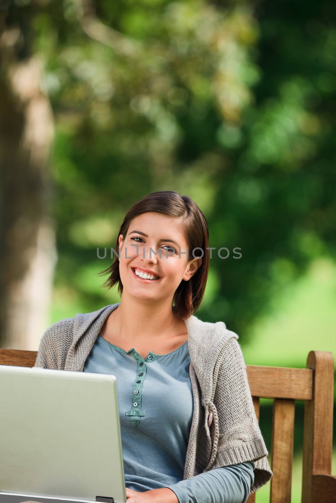 Woman working on her laptop in the park during the summer