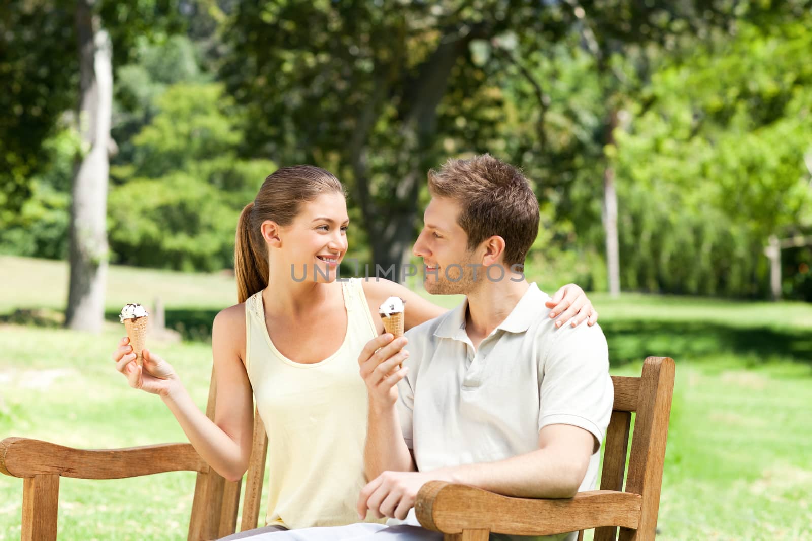 Couple eating an ice cream in the park by Wavebreakmedia