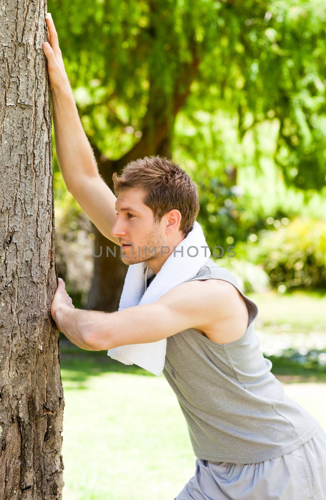 Man doing his stretches in the park during the summer