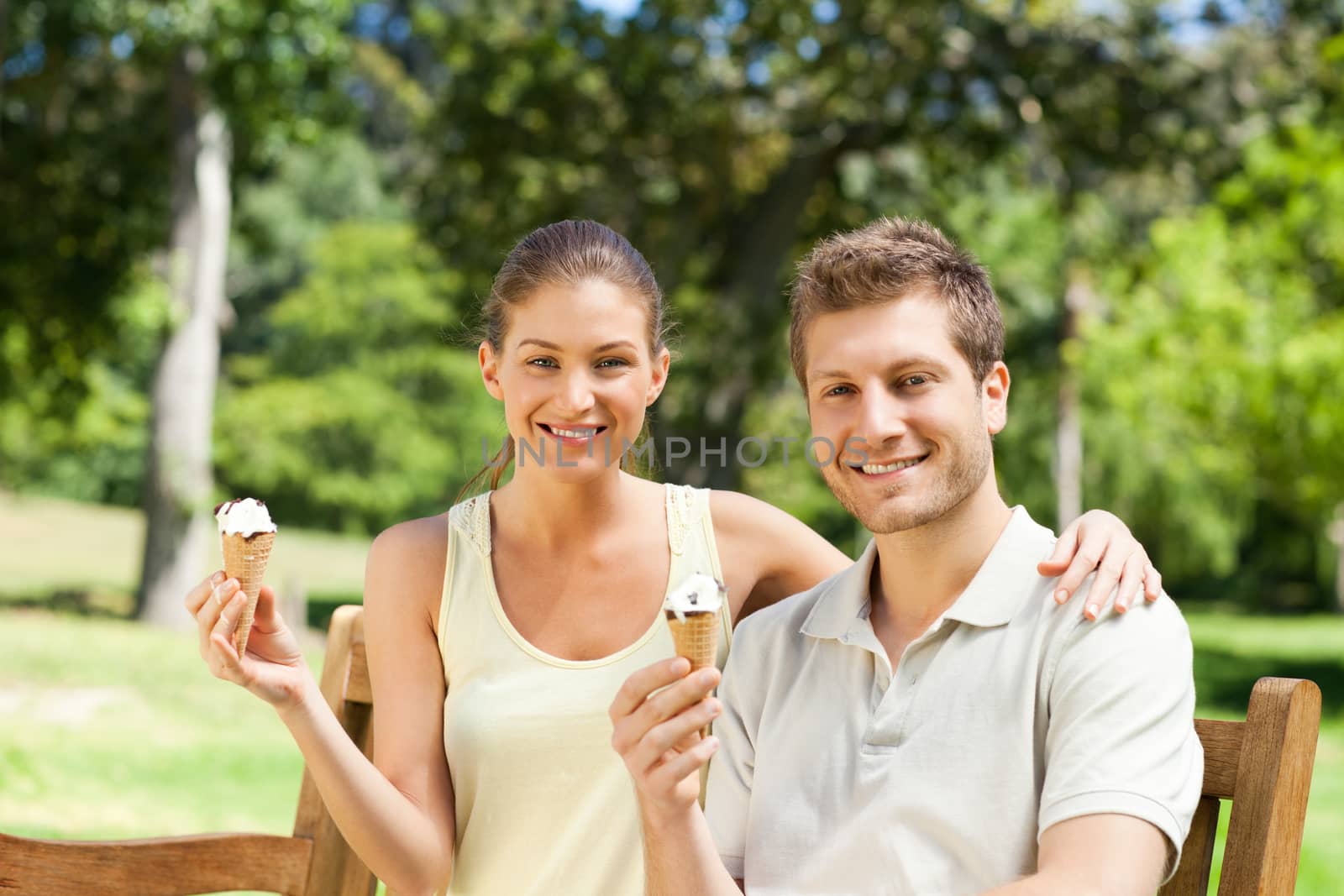 Couple eating an ice cream in the park during the summer