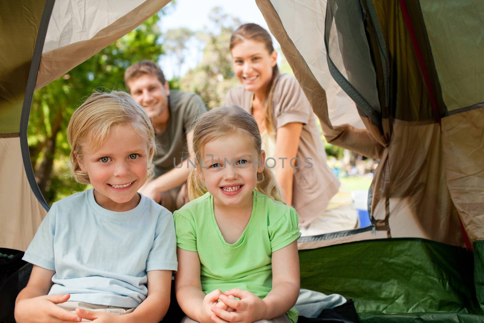 Happy family camping in the park during the summer