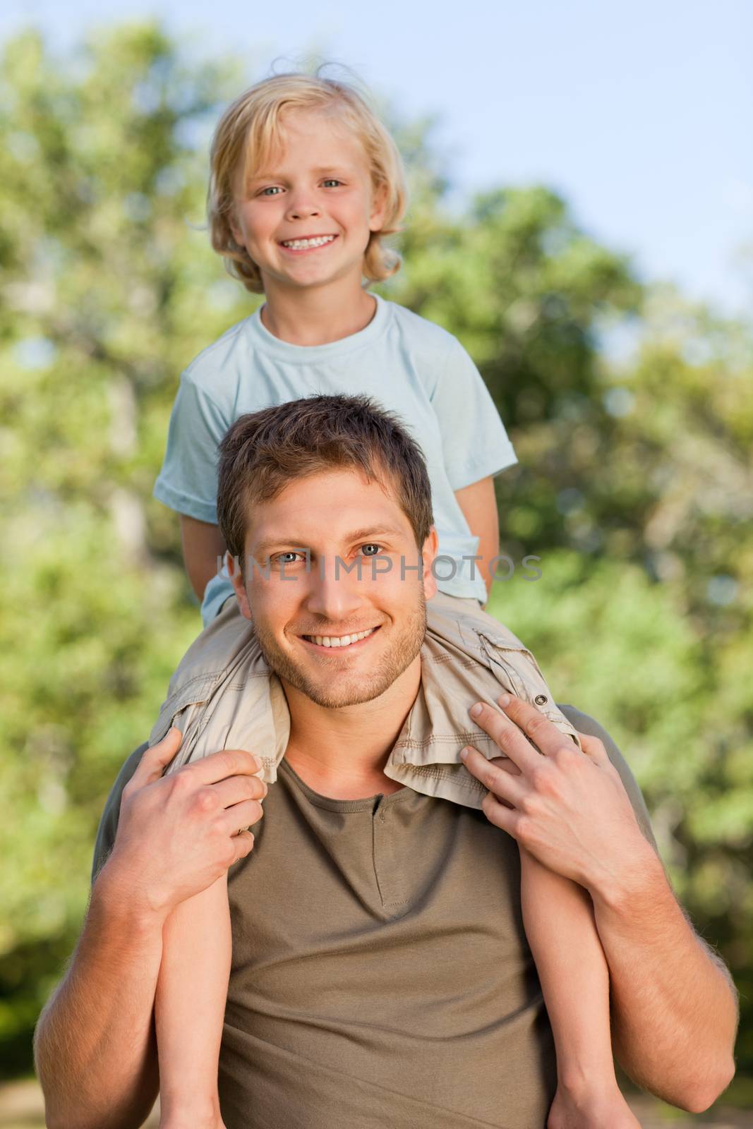 Father giving son a piggyback during the summer