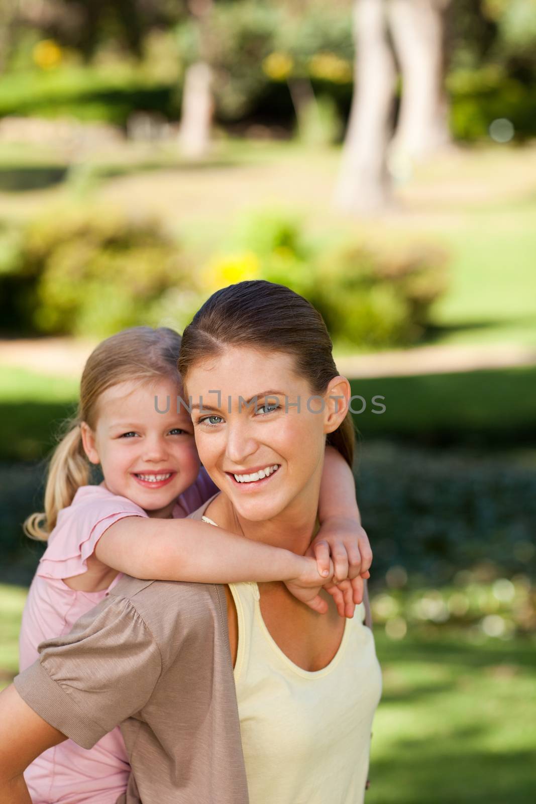 Beautiful mother giving daughter a piggyback by Wavebreakmedia