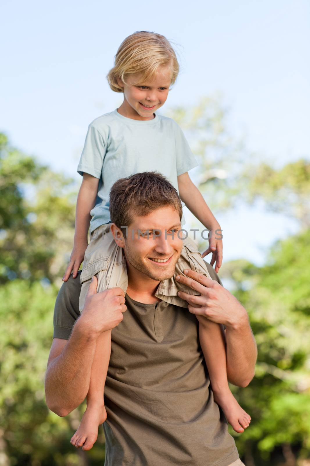 Father giving son a piggyback during the summer