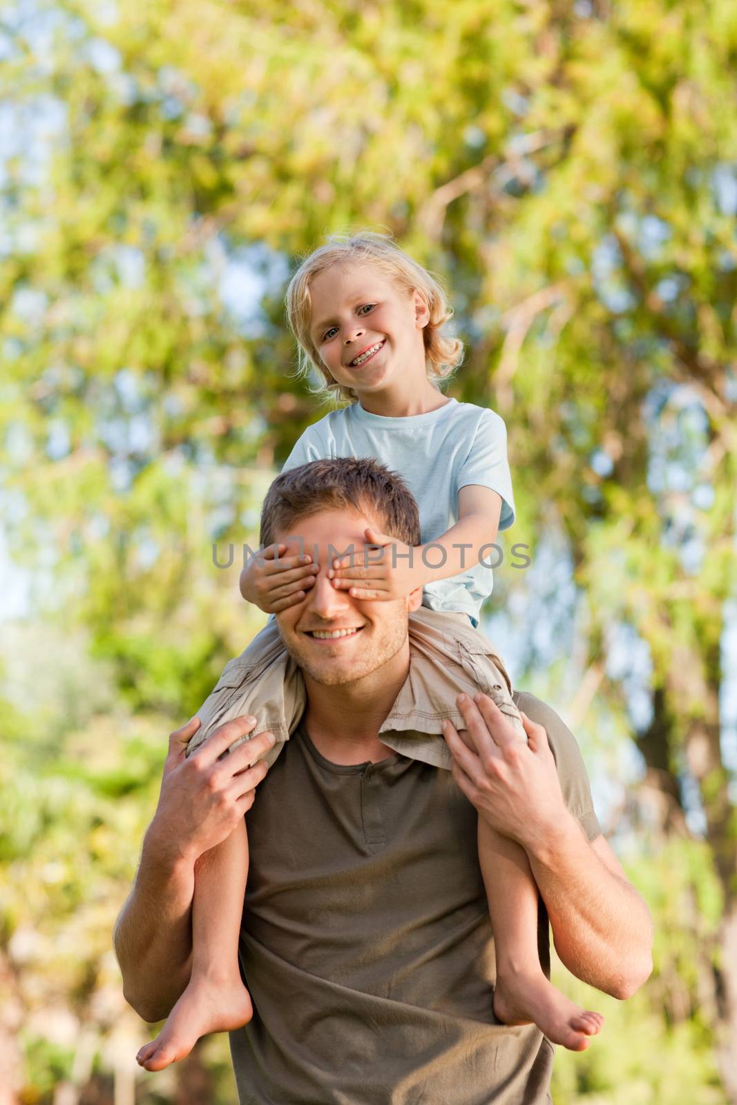 Happy father giving son a piggyback during the summer