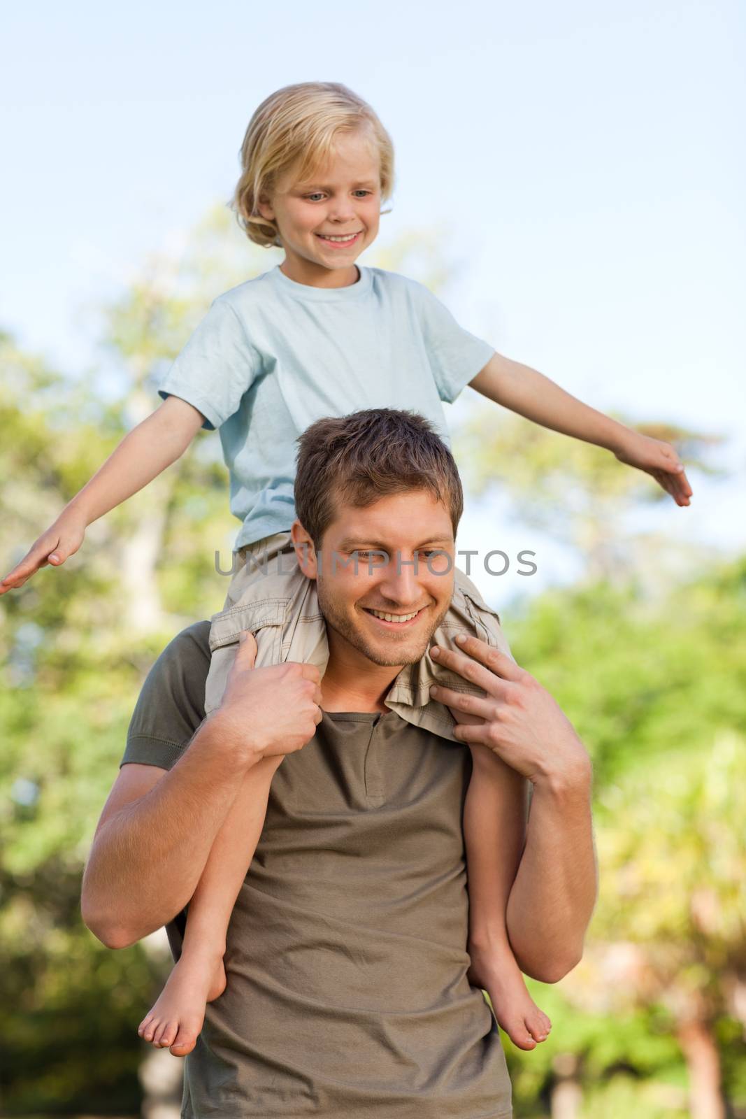 Father giving son a piggyback by Wavebreakmedia