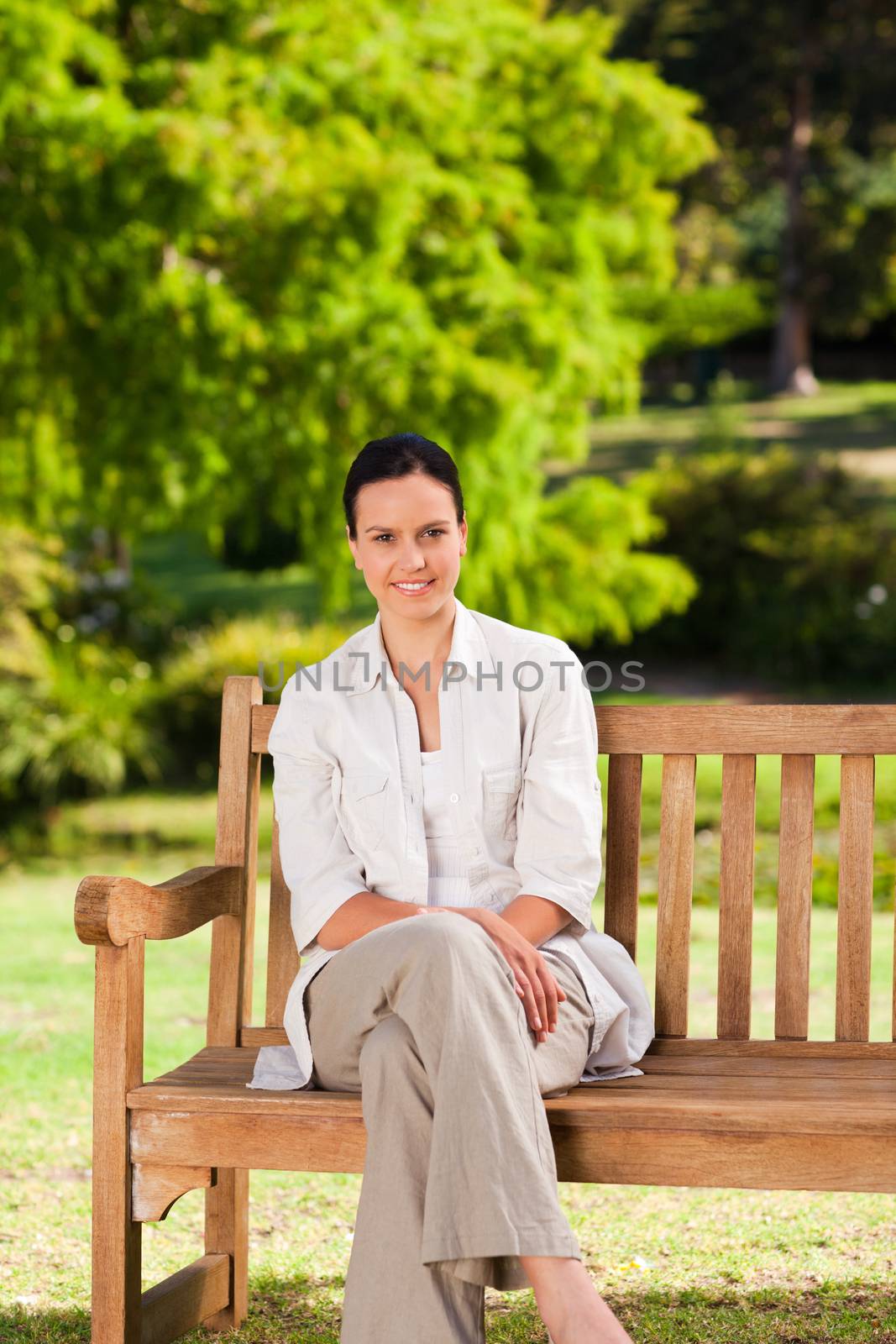 Brunette woman on the bench during the summer