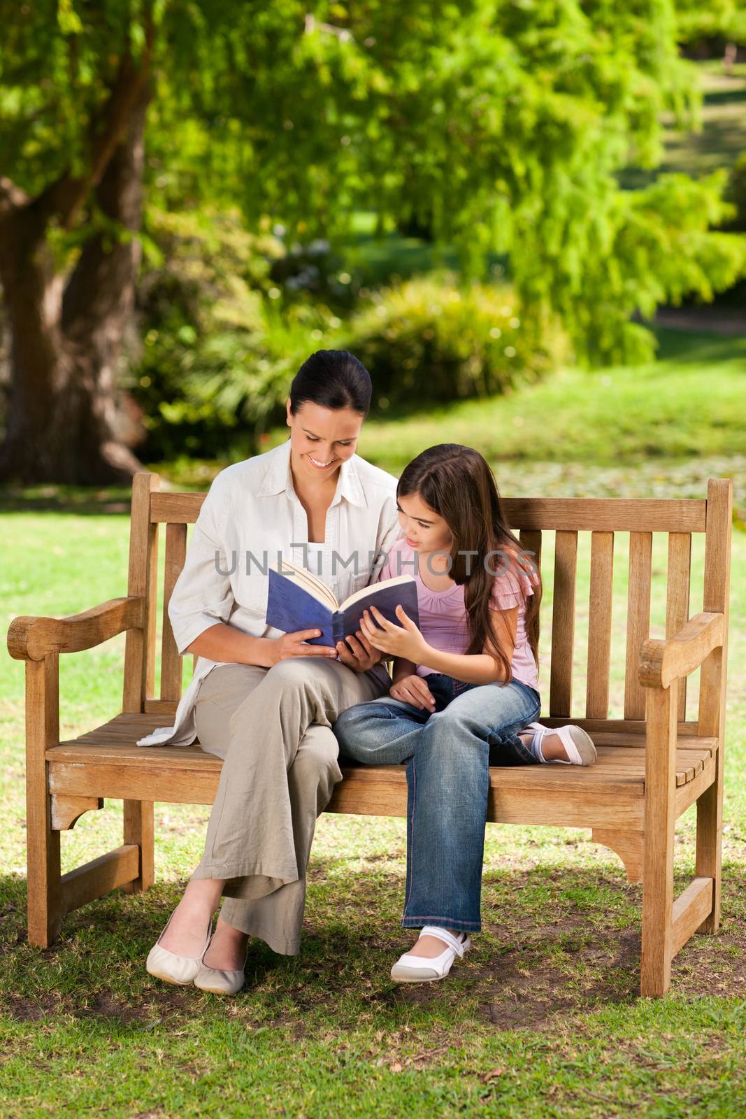 Mother and her daughter reading a book by Wavebreakmedia