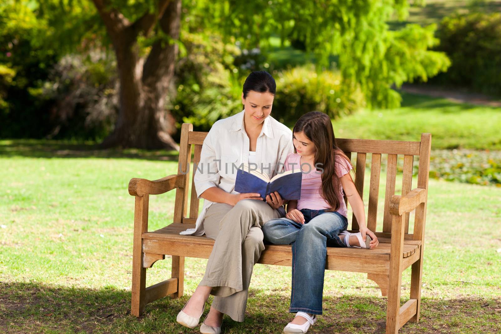 Mother and her daughter reading a book by Wavebreakmedia