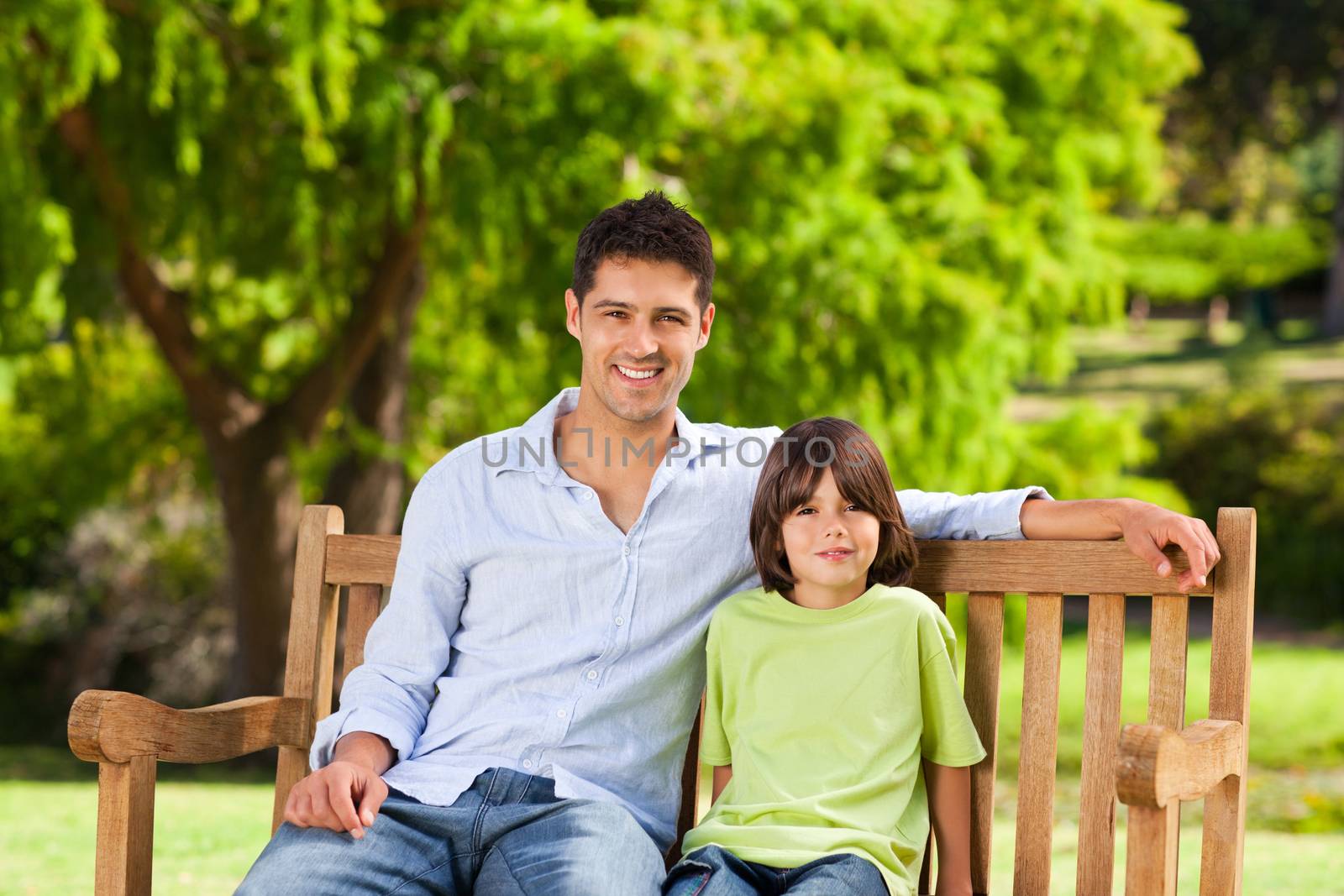 Father with his son on the bench during the summer