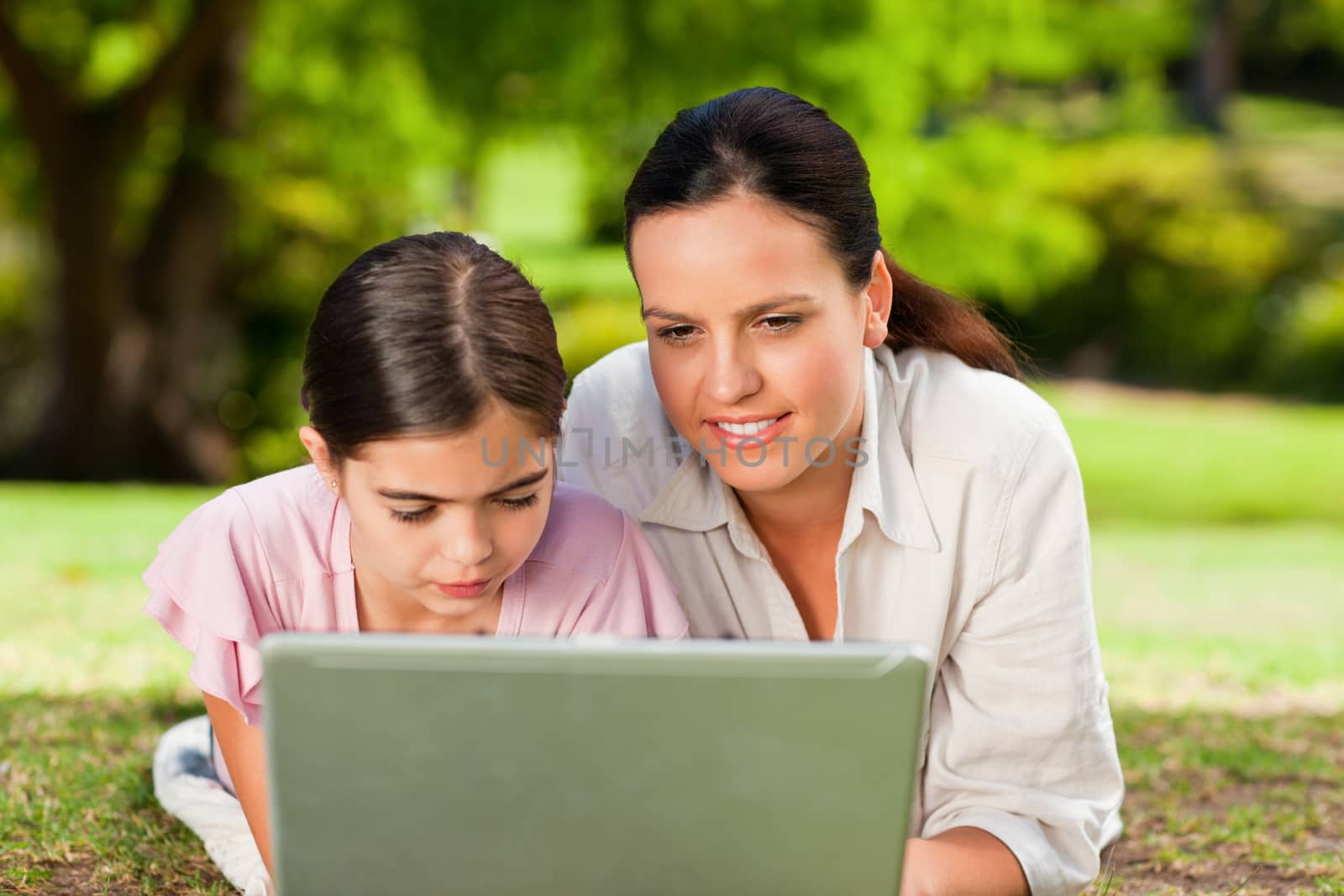 Mother and her daughter looking at their laptop during the summer