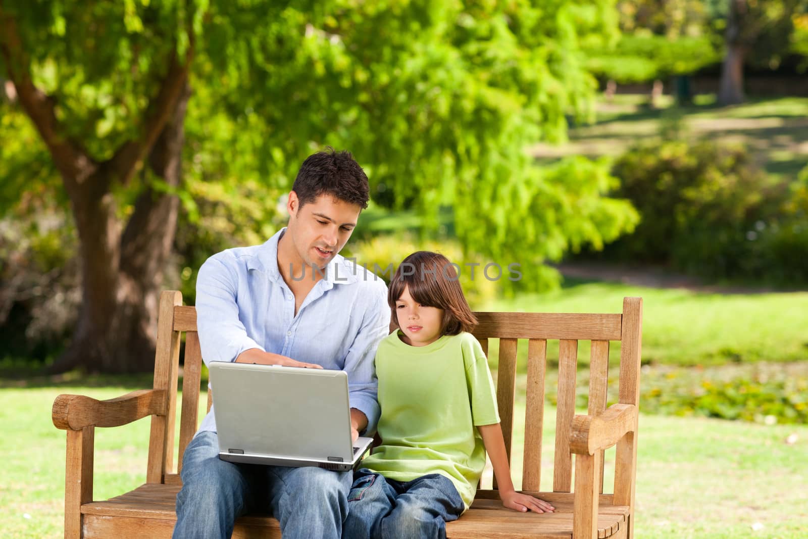 Son with his father looking at their laptop by Wavebreakmedia
