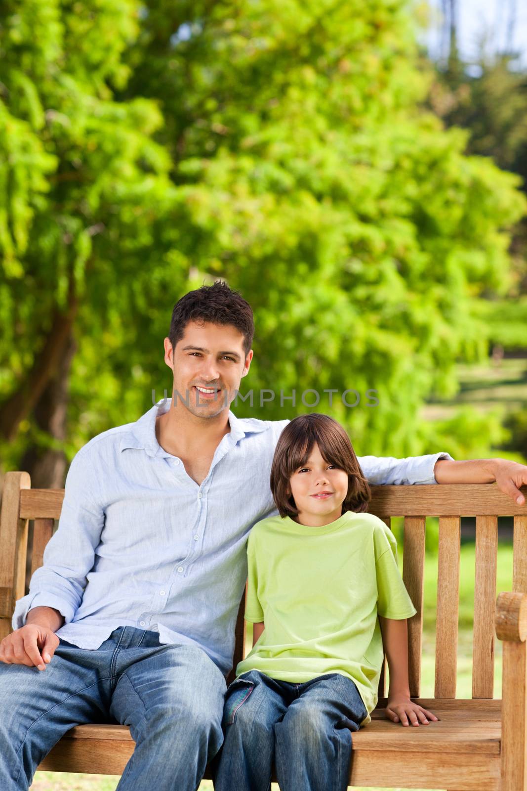 Father with his son on the bench during the summer