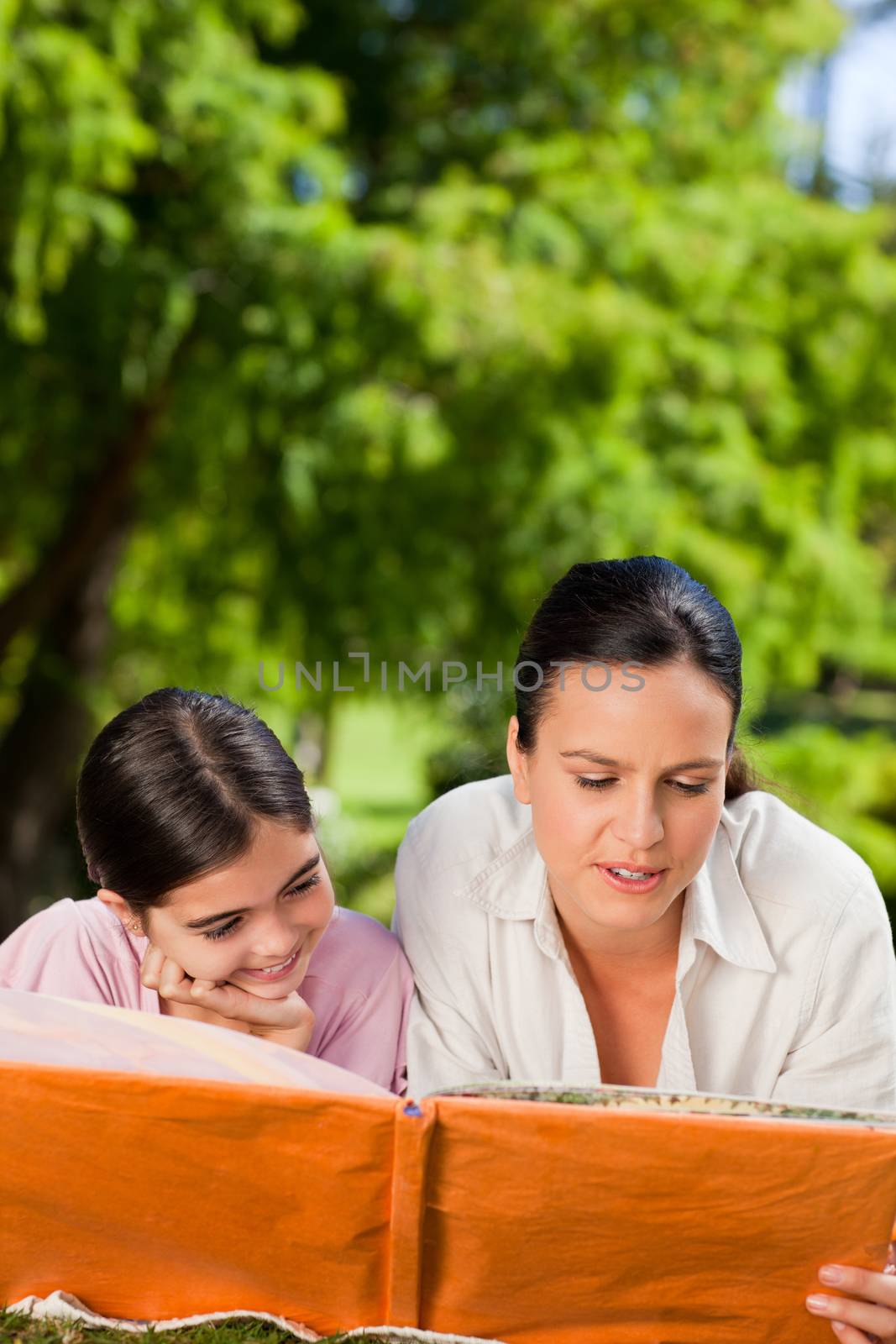 Mother and her daughter looking at their album photo during the summer