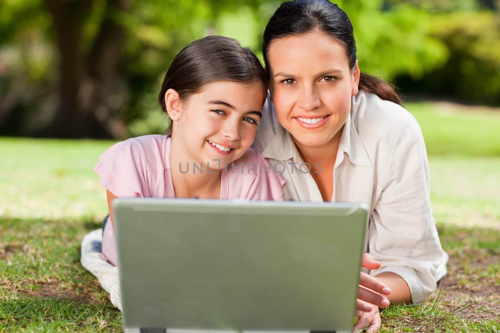 Mother and her daughter looking at their laptop during the summer