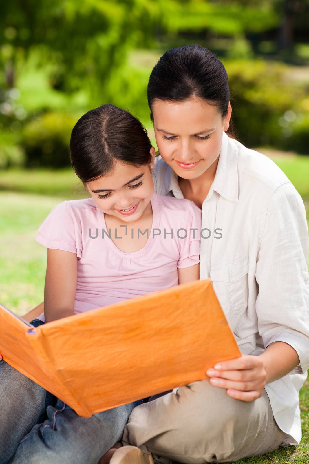 Daughter and her mother looking at their album photo during the summer 