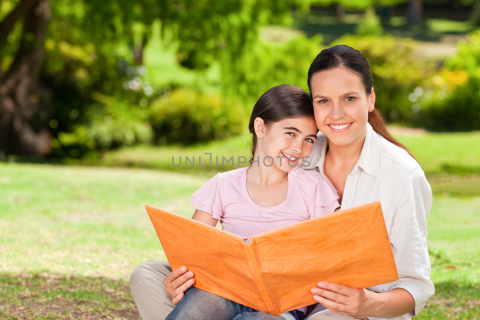 Daughter and her mother looking at their album photo during the summer 