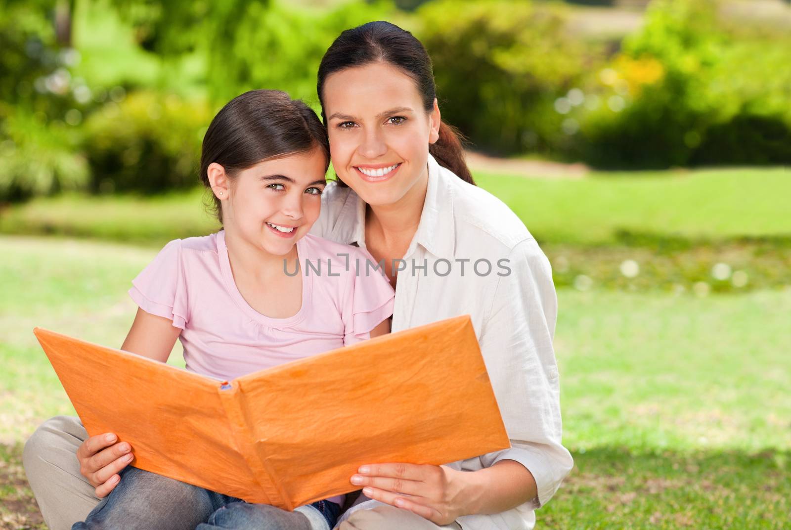 Daughter and her mother looking at their album photo during the summer 
