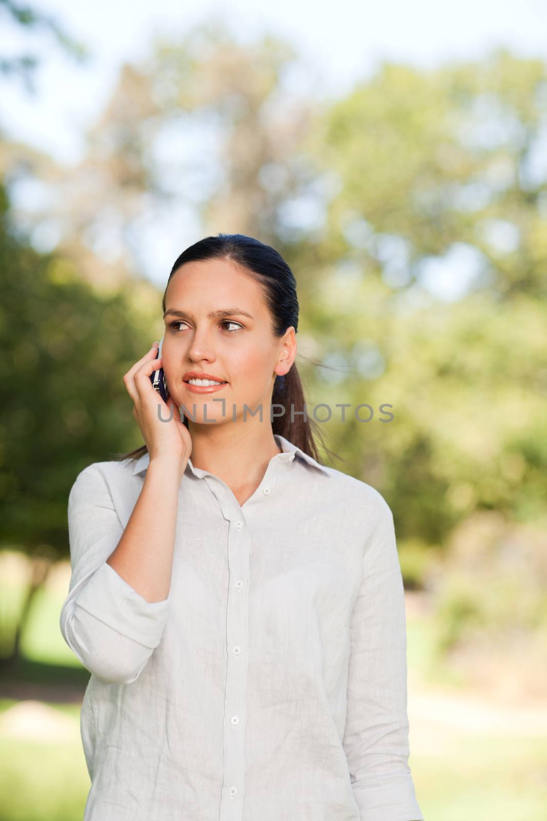 Woman phoning in the park by Wavebreakmedia