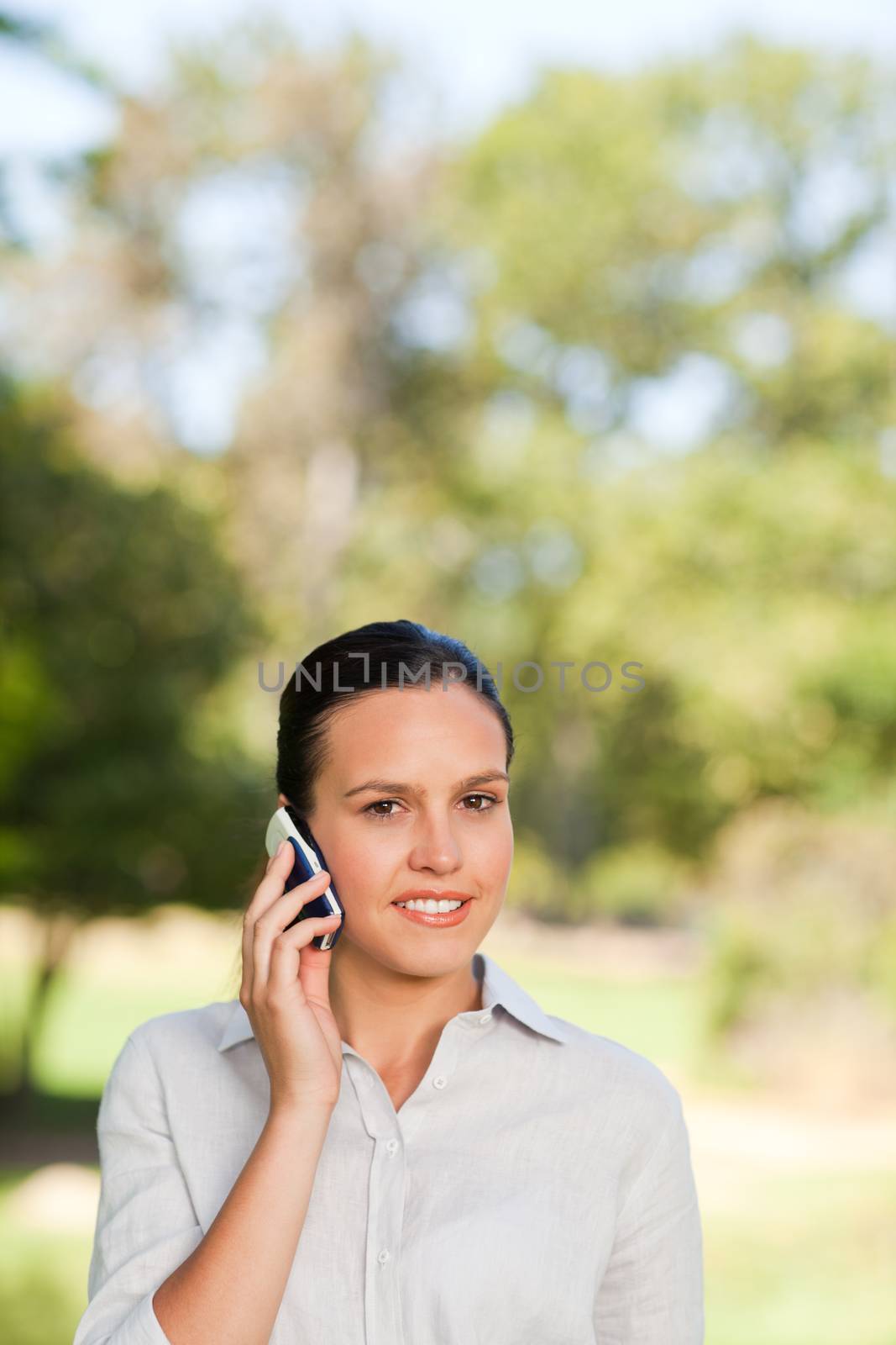 Woman phoning in the park during the summer