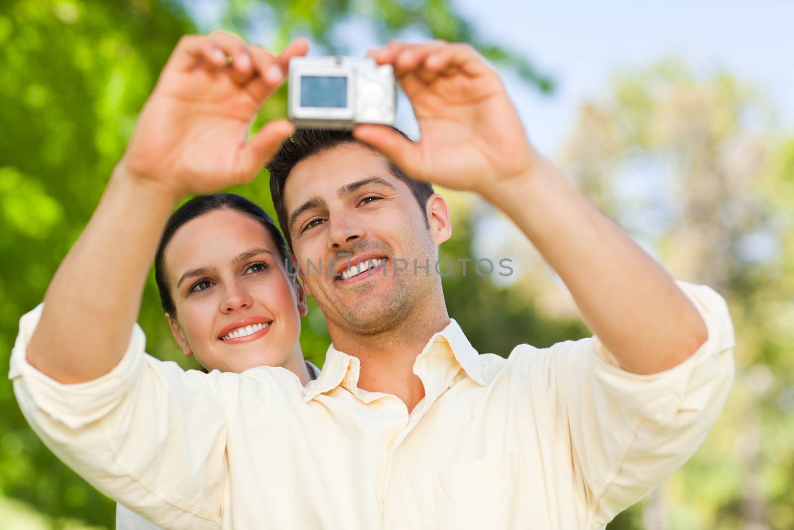Couple taking a photo of themselves in a park