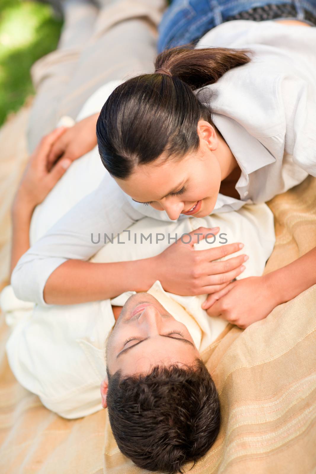 Happy couple lying down in the park by Wavebreakmedia