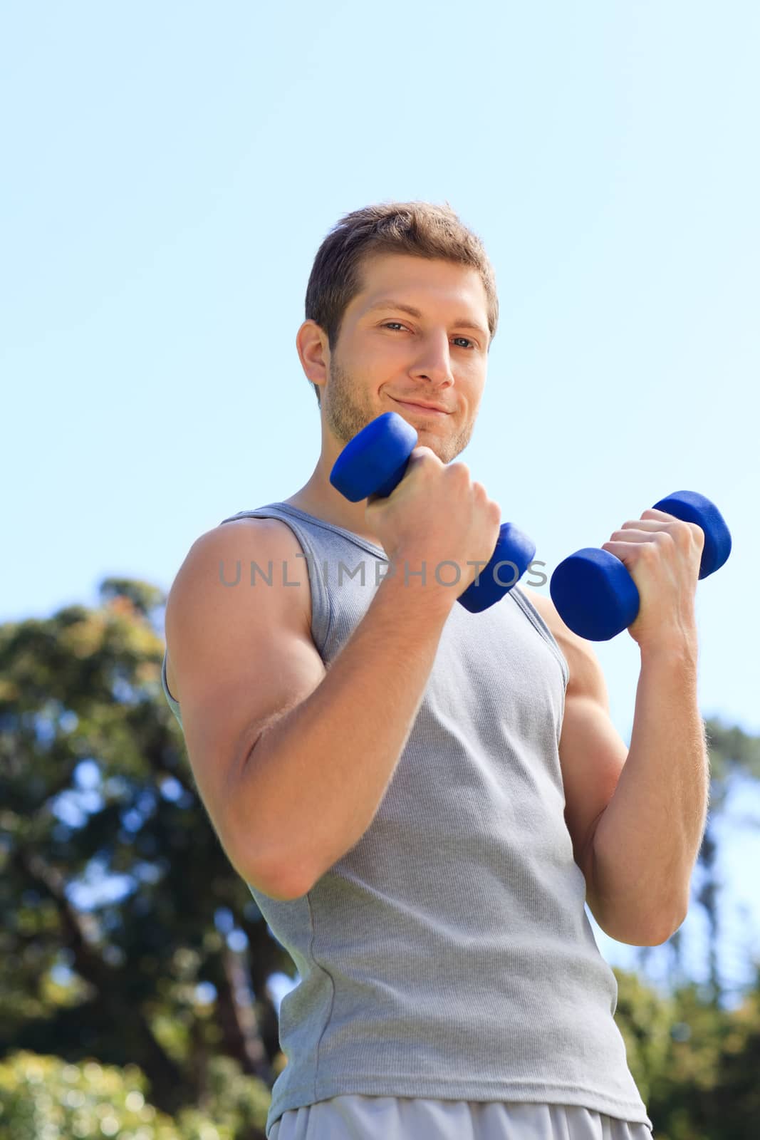 Young man doing his exercises in the park during the summer