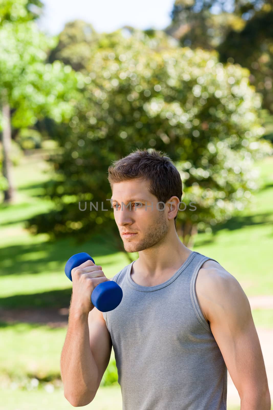 Young man doing his exercises in the park during the summer