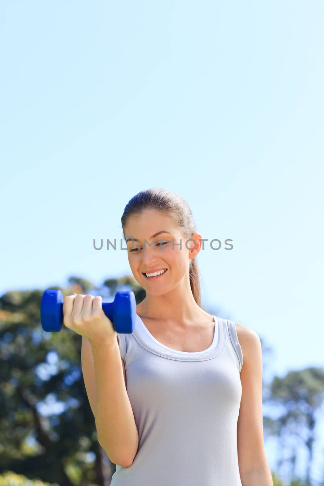 Young woman doing her exercises in the park during the summer